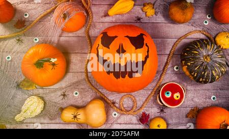 Citrouille automne halloween décor sur un bureau en bois. Une lanterne et des araignées effrayantes marchent entre les citrouilles. Scène effrayante d'halloween Banque D'Images