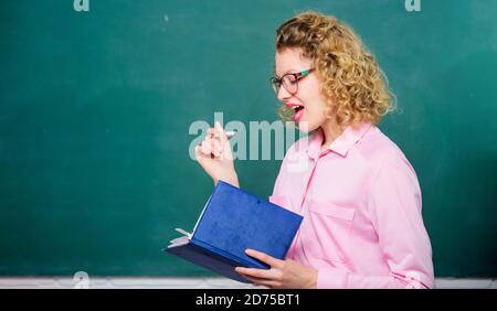 Femme enseignante devant le tableau de surveillance. Passionné par la connaissance. Pédalo tenir le livre et expliquer l'information. Concept d'éducation. Le professeur explique le sujet dur. Professeur meilleur ami des apprenants. Banque D'Images