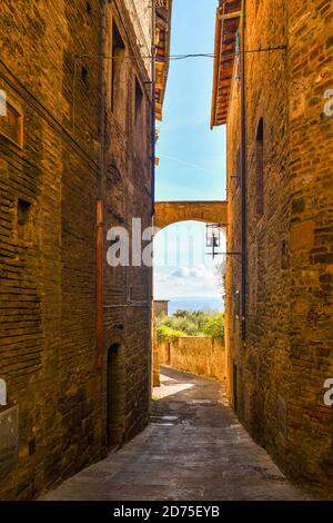 Aperçu d'une ruelle étroite dans le centre historique de la ville médiévale de San Gimignano, site classé au patrimoine mondial de l'UNESCO, Sienne, Toscane, Italie Banque D'Images