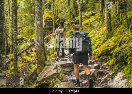 Randonnée couple randonneurs randonnée sentier forestier en automne nature aller camper avec des sacs à dos. Amis femme et homme marchant en montée sur la montagne au Québec Banque D'Images
