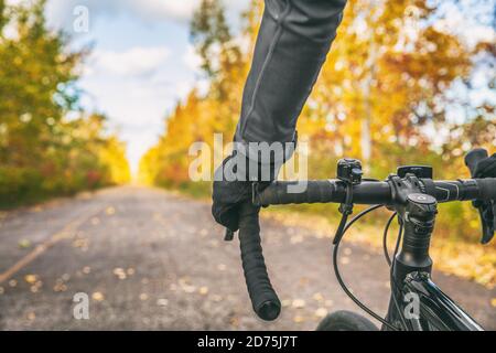 Vélo première personne vue de vélo cycliste POV montrant les mains et le guidon sur la route à vélo sur les trajets en extérieur automne nature Banque D'Images