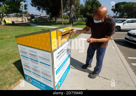 Burbank, CA. 26 juillet 2020. Un homme portant un masque de visage dépose son bulletin dans une boîte de vote officielle Mardi, 20 octobre 2020, à Burbank, en Californie. Crédit: Ringo Chiu/ZUMA Wire/Alay Live News Banque D'Images