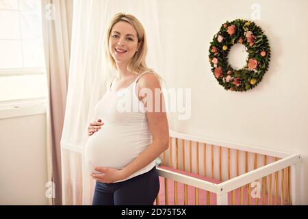 femme enceinte sur le lit à la maison Banque D'Images