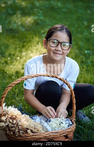 Portrait d'une fille cueillant des fleurs dans le parc Banque D'Images