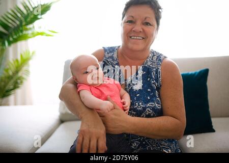 Grand-mère sur le canapé avec bébé à la maison Banque D'Images