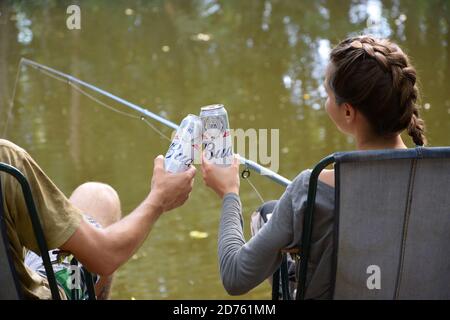 KHARKOV, UKRAINE - AOÛT 22 2020 : cheers garçons et filles avec Budweiser Lager alcool la bière peut pendant la pêche. Budweiser est la marque d'Anheuser-Busch in Banque D'Images