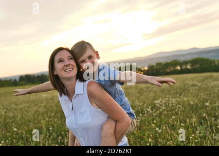 bonne famille de mère et d'enfant sur le terrain coucher de soleil s'amuser Banque D'Images