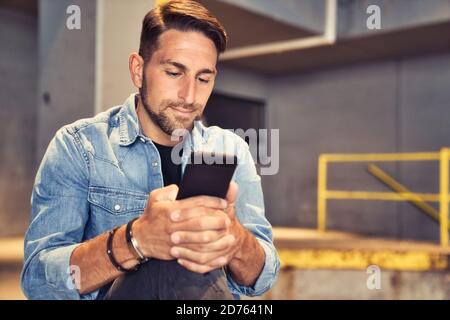 homme sur le fond de sous-sol dans la ville en utilisant le téléphone cellulaire Banque D'Images