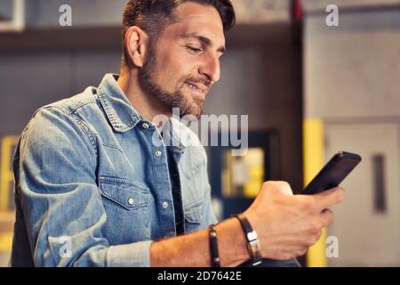 homme sur le fond de sous-sol dans la ville en utilisant le téléphone cellulaire Banque D'Images