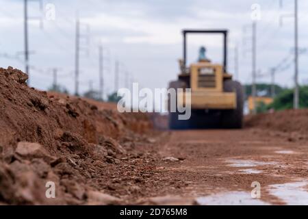 Compacteur de sol vibrant jaune flou travaillant sur la construction de routes, compacteur de sol vibrant jaune sur le chantier de construction de routes Banque D'Images