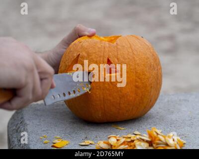 Homme utilisant un couteau sculptant une citrouille pour Halloween lanterne Banque D'Images