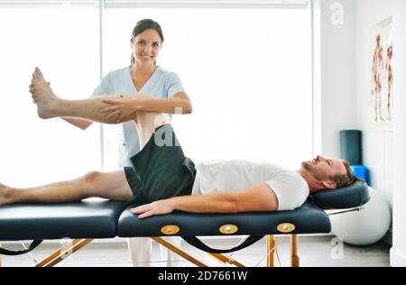 physiothérapeute faisant le traitement avec le patient dans le bureau lumineux avec la jambe formation Banque D'Images