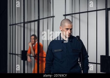 Un surveillant en uniforme dans une prison asiatique fait une visite en soirée des cellules avec des prisonniers. Banque D'Images