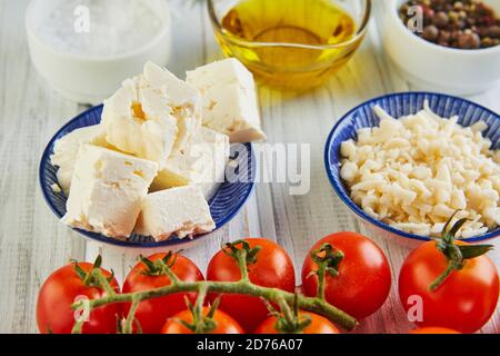 Ingrédients pour les tomates cerises de lasagne, le fromage, le beurre, les poivrons et les herbes. La nourriture est un pas. Banque D'Images