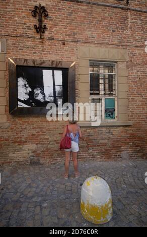 Un touriste observe l'un des magnifiques noirs et blancs de Giacomelli Photos affichées le long des rues de Mondolfo