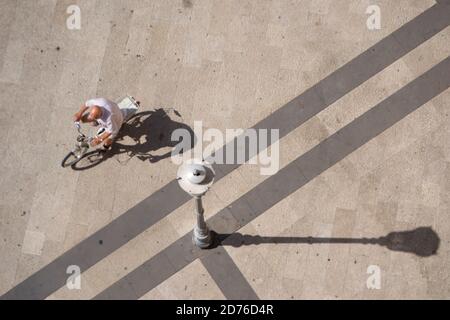 un homme fait un vélo sous le soleil d'été Une place dans la ville de Fondi Banque D'Images