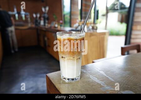 Gros plan sur un verre de café glacé latte en acier inoxydable paille Banque D'Images