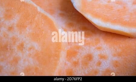 Tranchez les patates douces l'une sur l'autre dans une casserole en céramique. L'agrafe orange vif est un substitut sain pour la pomme de terre ou les frites. Banque D'Images