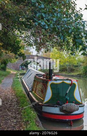 pont au-dessus du canal de la grande union avec des bateaux étroits et des barges amarrés le long du chemin de halage à braunston, daventry, royaume-uni Banque D'Images