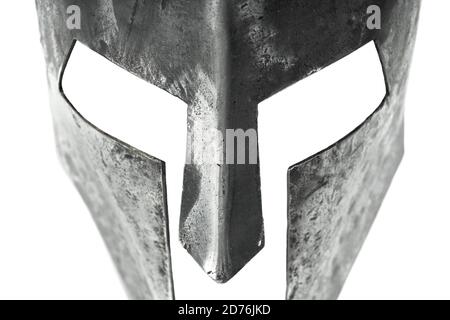 Vue rapprochée de l'ancien casque en fer spartan isolé sur fond blanc de studio. Armure médiévale, souvenir archéologique du passé, protection de la tête robuste en métal. Banque D'Images