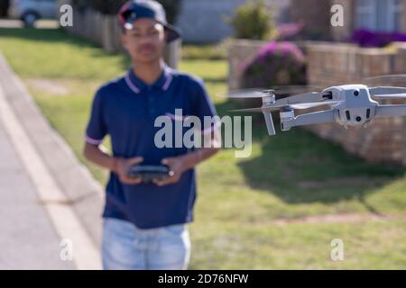 Drone planant en plein air avec un arrière-plan flou d'un jeune garçon contrôlant à distance. Photo de haute qualité Banque D'Images