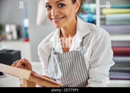 Femme souriante en cliquant sur une tablette tout en travaillant dans un magasin Banque D'Images