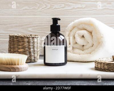 Maquette pour produits de bain dans la salle de bain, shampooing spa, gel douche, savon liquide avec une serviette à côté et divers accessoires Banque D'Images