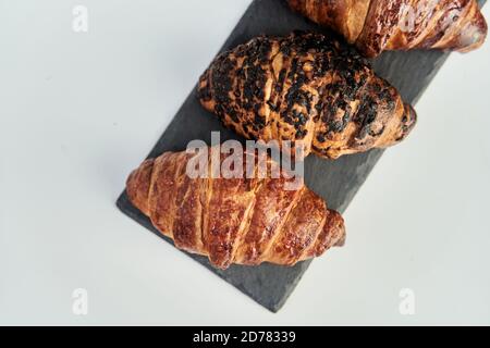 trois croissants sur un plateau noir vue sur le dessus Banque D'Images