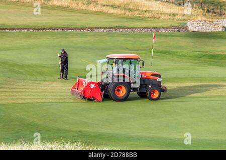 Greenkeepers travaillant sur le dix-huitième vert de mise à Carnoustie Championship Golf Links, Carnoustie, Angus, Écosse, Royaume-Uni Banque D'Images