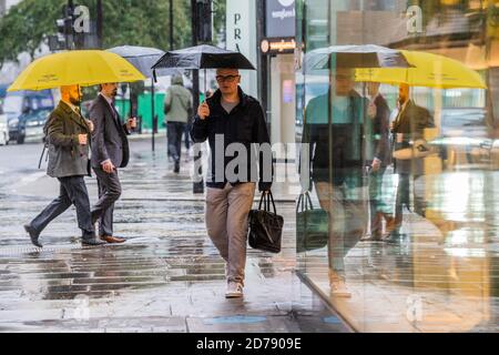 Londres, Royaume-Uni. 21 octobre 2020. Les parasols sont en haut de l'esprit étouffant dans Oxford Street. Les temps sont difficiles pour les détaillants car les restrictions au moment où la pluie tombe et au coronavirus commencent à augmenter à nouveau. Crédit : Guy Bell/Alay Live News Banque D'Images