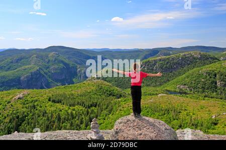 Une jeune randonneur appréciant le paysage au sommet du Mont-du-Lac-des-Cygnes dans le parc national des Grands Jardins, Québec, Canada Banque D'Images