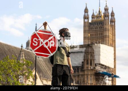 Manifestant dans un masque à gaz portant un panneau d'arrêt lors d'une manifestation de rébellion d'extinction, Parliament Square, Londres, 10 septembre 2020 Banque D'Images