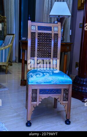 Une ancienne chaise arabe en bois d'origine, enveloppée de tissu bleu Banque D'Images