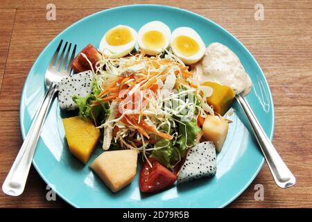 Assiette à salade mixte sur fond de photo en bois Banque D'Images