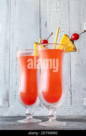 Deux verres de Singapore Sling sur fond de bois Banque D'Images