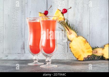 Deux verres de Singapore Sling sur fond de bois Banque D'Images