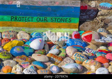 Protégez nos pierres panneau et pierres colorées peintes à la main célébrant The NHS on Avon Beach Christchurch Royaume-Uni Banque D'Images