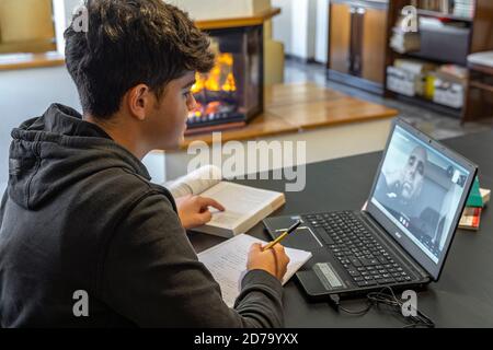 homeschooling. Un jeune étudiant a été relié à un professeur avec un ordinateur portable à la maison pendant la crise de santé Covid-19 Banque D'Images