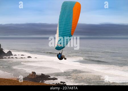 Vila do Bispo, Portugal - 12 février 2020 : un parapente survolant les falaises pittoresques de la plage de Cordoama (Praia da Cordoama) près du village de Banque D'Images