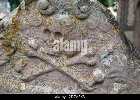 La pierre d'appui de la tombe ancienne avec le crâne et les crossos est un symbole d'un crâne humain avec deux longs os croisés en dessous. Banque D'Images