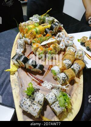 Gros plan vertical de différents rouleaux de sushis plaqués sur un Bois dans un restaurant japonais Banque D'Images