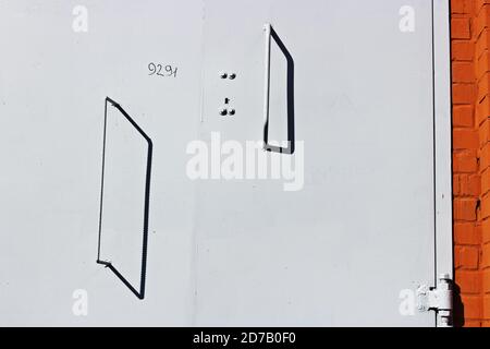 Portes en métal fraîchement peintes avec poignées de cabine tranformer urbaine dans un mur de briques Banque D'Images