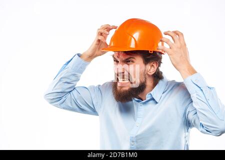 Homme en colère dans orange casque dur industrie travail insatisfaction pantacourt vue Banque D'Images