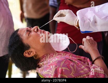 Guwahati, Assam, Inde. 21 octobre 2020. Un travailleur de la santé en équipement de protection individuelle (EPI) recueille un échantillon d'écouvillonnage nasal auprès de la population locale pour le test rapide d'antigène Covid-19 (RAT), dans un centre de collecte de Swab en prévision du festival de la puja de durga. Un total cumulé de 9, 72, 00,379 échantillons a été testé. Crédit : David Talukdar/ZUMA Wire/Alay Live News Banque D'Images