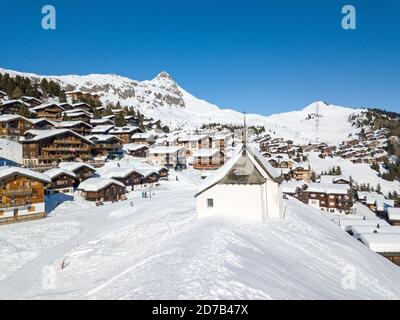 Bettmeralp, Suisse - février 16. 2019 : image aérienne de la chapelle Maria in Snow (Kapelle zum Schnee) avec le village des alpes suisses Bettmeralp en C. Banque D'Images