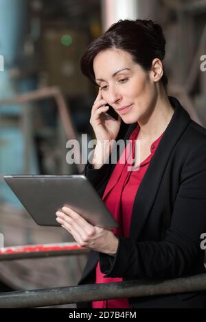 Jolie warehouse manager à l'aide de tablet pc dans un grand entrepôt Banque D'Images