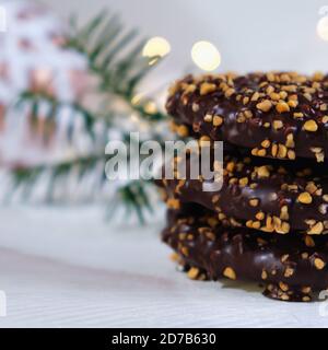 L'ambiance de l'Avent et de Noël, gâteau au miel empilé, joliment décoré sur une table en bois blanc en arrière-plan un boule de noël blanche et de lumière Banque D'Images