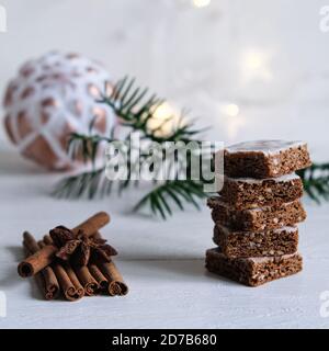 L'ambiance de l'Avent et de Noël, gâteau au miel empilé, joliment décoré sur une table en bois blanc en arrière-plan un boule de noël blanche et de lumière Banque D'Images