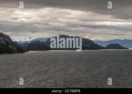 Canal de Sarmiento, Chili - 11 décembre 2008 : glacier et fjord Amalia. Les cieux plus légers rivalisent avec les nuages bruns. Neige sur le sommet de la montagne. Banque D'Images