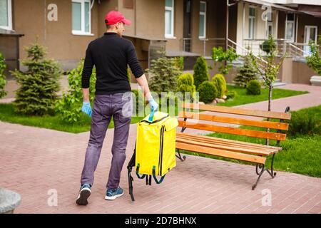 concept de livraison, de courrier et de personnel - un homme heureux livrant de la nourriture dans un sac en papier jetable à la maison du client Banque D'Images